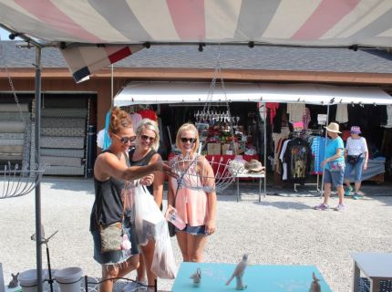 Three ladies looking at a wire planter at the Shipshewana Flea Market