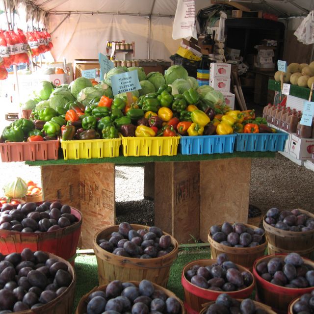 Fresh Plums and Green Peppers for sale at the Shipshewana Flea Market in the Farmer's Market aisle